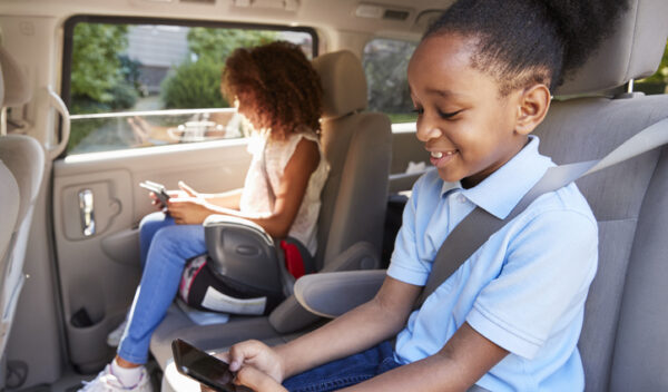 Children Using Digital Devices On Car Journey