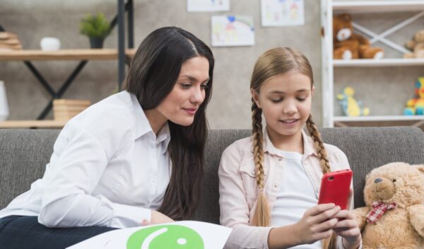 young-child-psychologist-looking-mobile-phone-hold-by-little-girl