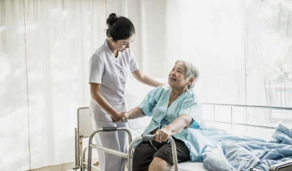 Young nurse take care of senior patient In Hospital Room